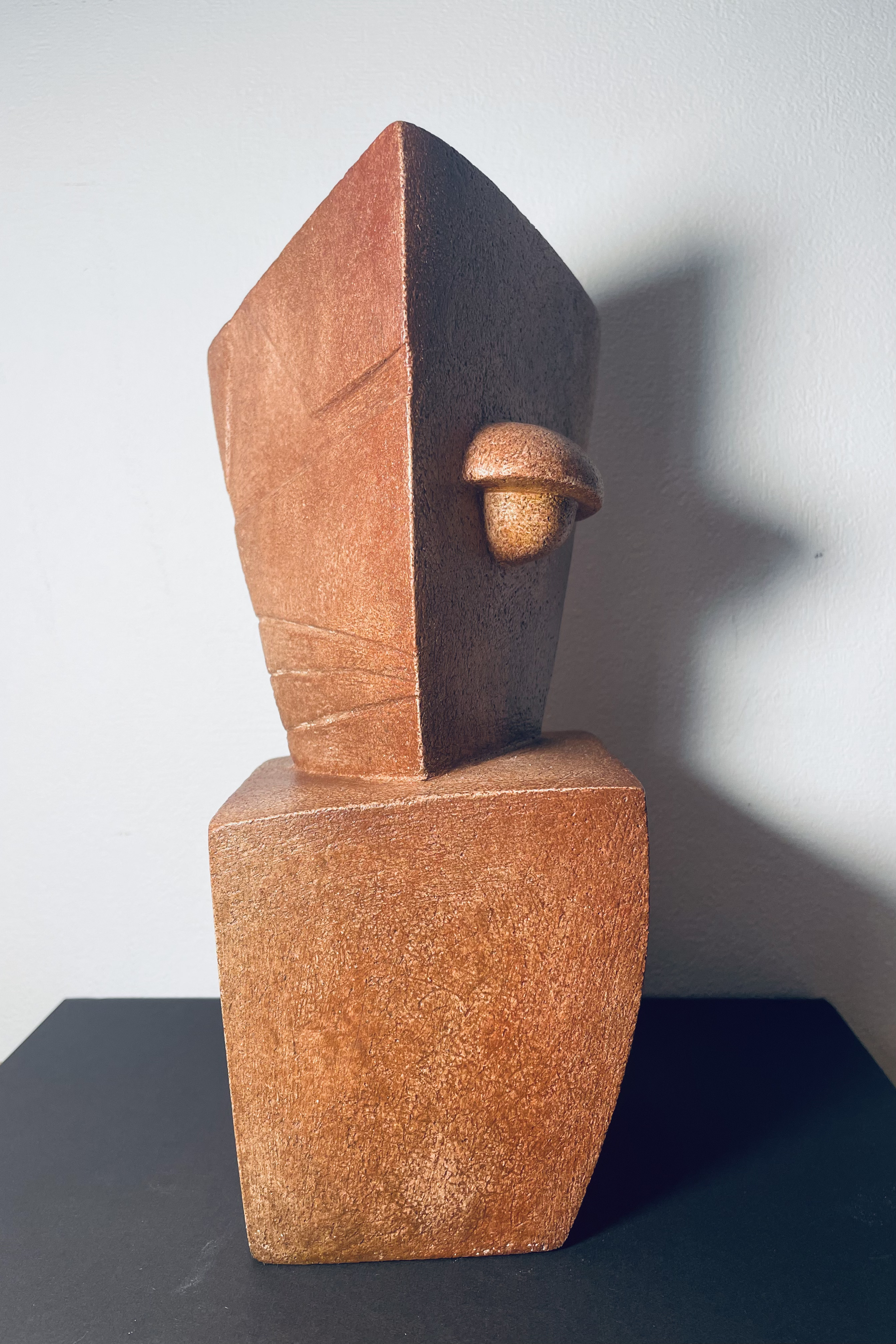 Ceramic sculpture: columnar body with triangular head featuring circular opening in vertical arrangement